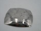 a metal object on a white surface with a white background