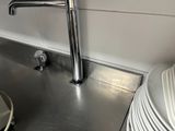 a sink that has a metal faucet in the middle of it
