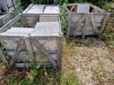 two wooden crates sitting in the grass next to each other