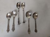 several spoons and spoon spoons are lined up on a white surface