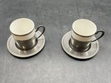 two cups and saucers are sitting on a table