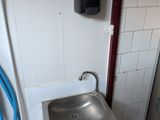 une salle de bains équipée d'un lavabo et d'un tuyau d'arrosage fixé au mur