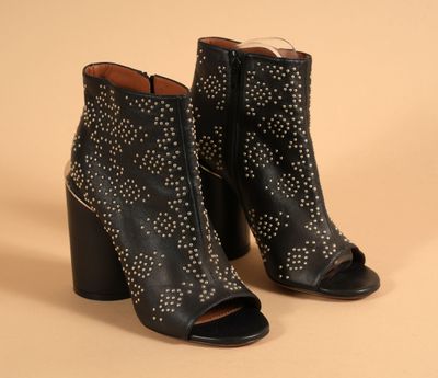 une paire de bottines en cuir noir ornées de clous argentés