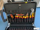 une mallette à outils posée par terre et contenant de nombreux outils