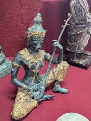 a statue of a woman sitting on a red table