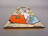 a picture of a painting of a clown on a piece of wood