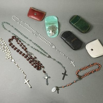 a lot of rosary and other religious items on the table