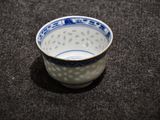 a blue and white bowl sitting on a black surface