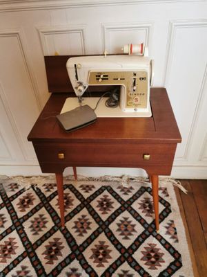 une machine à coudre posée sur une petite table dans une pièce