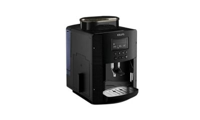 La machine à café est noire et il y a une tasse de café dessus.