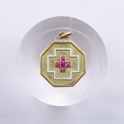 un pendentif doré et rose orné d'une croix