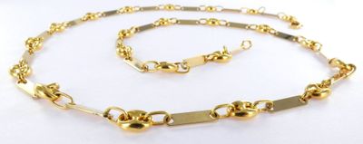 a close up of a necklace and bracelet on a white surface