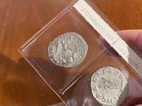 someone is holding a small box of silver coins on a table