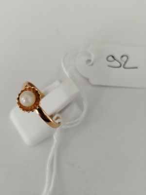 a close up of a gold ring with a pearl on it