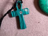 a green cross and a turquoise stone on a table