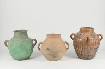 three vases with handles are sitting on a white surface