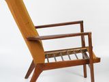 a brown chair with a wooden frame and armrest on a white background