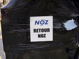 une pancarte sur laquelle est écrit « noz retour noz » à l'arrière d'une moto