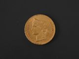 a close up of a gold coin on a black surface
