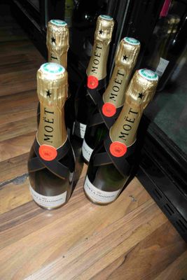Plusieurs bouteilles de champagne sont alignées sur une table en bois