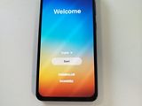 a close up of a cell phone on a table with a welcome screen