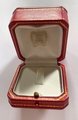 a small red box with a gold ring inside of it