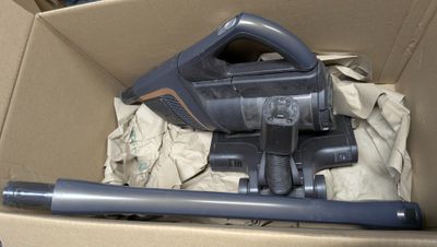 une boîte contenant un aspirateur et un tuyau