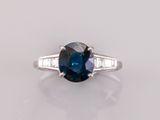 un gros plan sur une bague sertie d'un saphir bleu et de diamants