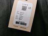 a luggage tag attached to the back of a black suitcase
