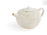 a white teapot with a white lid on a white surface