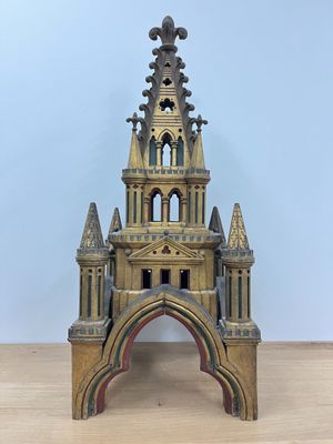 une vieille maquette en bois représentant une église surmontée d'un clocher