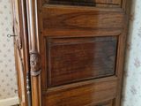 a wooden door in a room with floral wallpaper