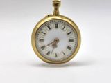 a small gold pocket watch with roman numerals on it