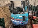 une petite pelleteuse bleue garée dans un garage