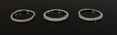 three silver rings sitting on top of a table next to each other
