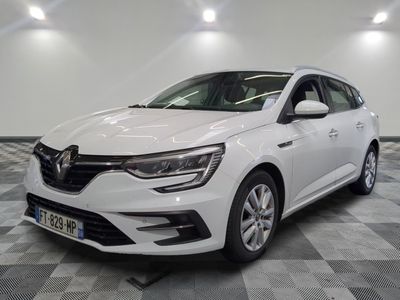 la voiture blanche est garée sur un sol en damier dans le garage