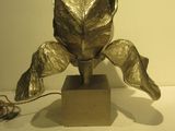 a metal sculpture of a flower on a wooden base