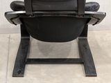a black chair that is sitting on a tile floor