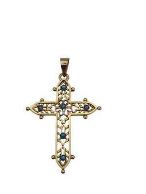 un pendentif en forme de croix en or, orné de pierres bleues sur fond blanc