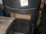 a man standing next to a black stove in a kitchen