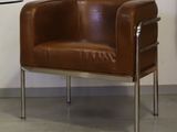 un fauteuil en cuir marron et une table en verre dans une pièce