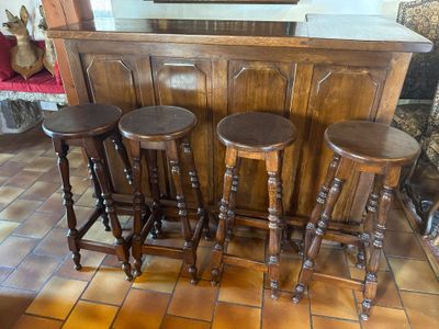 trois tabourets en bois placés devant un bar