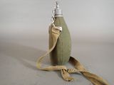 a small bottle with a strap on it sitting on a table