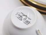 a close up of a white plate with a gold rim