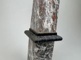 a marble sculpture with a black base on a white background