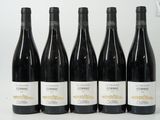six bouteilles de vin sont alignées sur une surface blanche