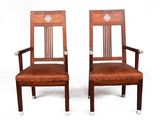 paire de chaises en bois avec des assises rembourrées de cuir, montées sur roulettes