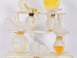 Plusieurs vases en verre sont empilés sur un support en bois