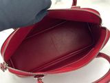 a person holding a red purse on a white surface