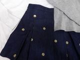 a skirt and sweater on a bed next to a pillow